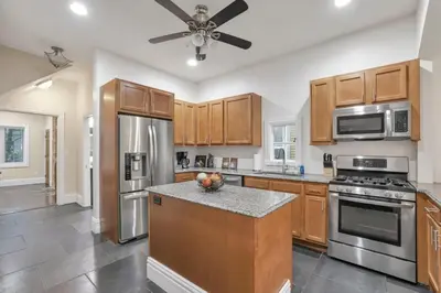 a kitchen with wooden cabinets and stainless steel appliances at OSU and Short North 4 Bedroom Patio and Garage with EV in Columbus