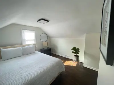 a bedroom with a white bed and a potted plant at New! Cozy 4-bedroom w/ free parking. Dogs welcome! in Berea
