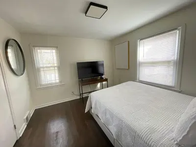 a bedroom with a bed and a flat screen tv at New! Cozy 4-bedroom w/ free parking. Dogs welcome! in Berea