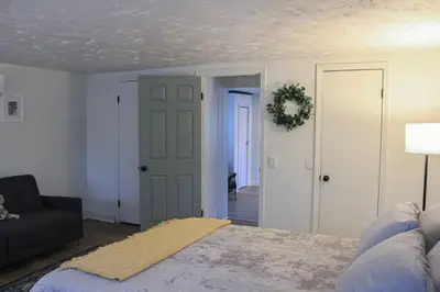 a bedroom with a bed and a couch and a living room at New 1-bedroom Bungalow! 4 miles to CLE in Berea