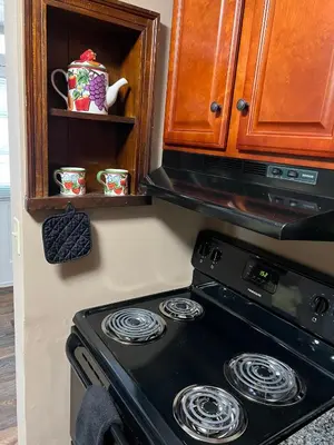 a stove in a kitchen with a cupboard and a microwave at Extended Stays by Lee House Inn in Maysville