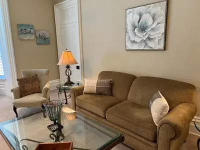 a living room with a couch and a glass table at Extended Stays by Lee House Inn in Maysville