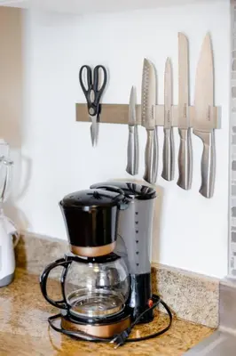 a coffee maker on a counter with knives on a wall at Georgetown Villas Nice Valley 3-4c & Creek Views! in Fairview Park