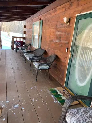 a row of chairs lined up on a porch at Cozy Creekside Cabin in the heart of Hocking Hills in Laurelville