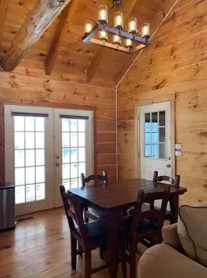 a dining room with a table and chairs in a cabin at Cozy Creekside Cabin in the heart of Hocking Hills in Laurelville