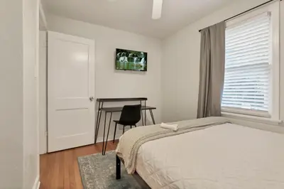 a bedroom with a bed and a desk and a window at Housepitality - The OSU Hideaway - 4 BR 5 min from OSU Grandview in Columbus