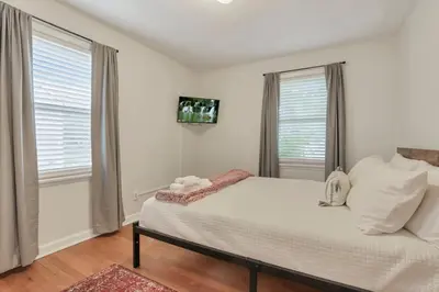 a bedroom with a bed and two windows at Housepitality - The OSU Hideaway - 4 BR 5 min from OSU Grandview in Columbus
