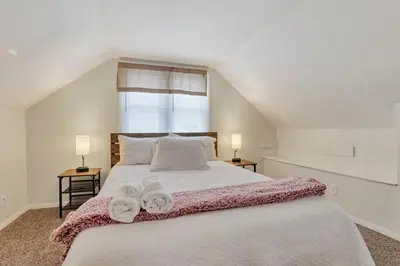 a bedroom with a large white bed with towels on it at Housepitality - The OSU Hideaway - 4 BR 5 min from OSU Grandview in Columbus