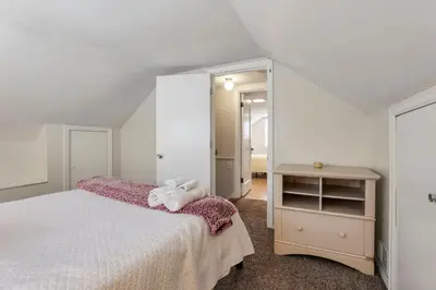a bedroom with a bed with a teddy bear on it at Housepitality - The OSU Hideaway - 4 BR 5 min from OSU Grandview in Columbus