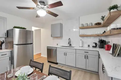 a kitchen with white cabinets and a ceiling fan at Housepitality - The OSU Hideaway - 4 BR 5 min from OSU Grandview in Columbus