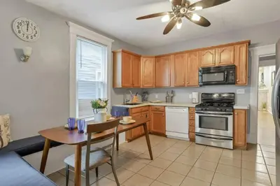 a kitchen with a table and a ceiling fan at Housepitality - Harrison Mansion - Great Location in Columbus