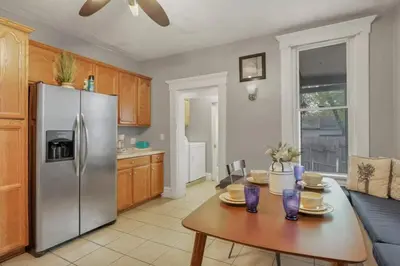a kitchen with a table and a stainless steel refrigerator at Housepitality - Harrison Mansion - Great Location in Columbus