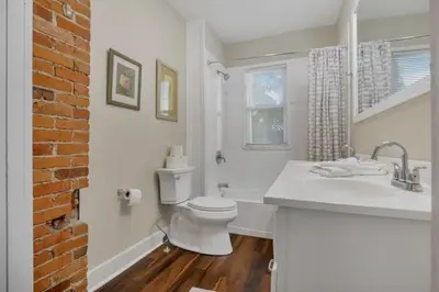 a white bathroom with a toilet and a sink at Housepitality - Harrison Mansion - Great Location in Columbus