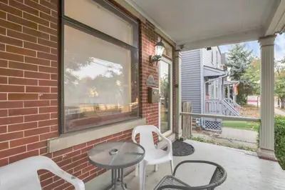 a patio with two chairs and a table and a window at Housepitality - Harrison Mansion - Great Location in Columbus