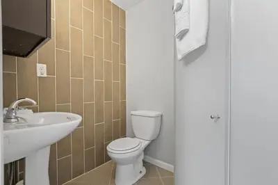 a bathroom with a toilet and a sink at Housepitality - The Restful Studio - Cozy in Newark