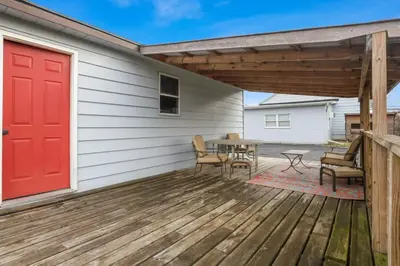 a red door on a deck with a table and chairs at Housepitality - The Restful Studio - Cozy in Newark