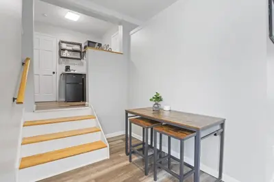 a small kitchen with a table and a staircase at Housepitality - The Restful Studio - Cozy in Newark