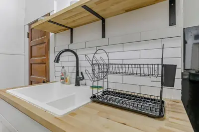 a kitchen sink with a dish drying rack on the counter at Housepitality - The City Gateway in Columbus