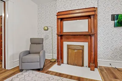 a living room with a chair and a fireplace at Housepitality - The City Gateway in Columbus