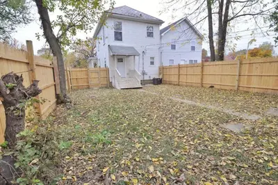 a yard with a fence and a white house at Housepitality - The Lilley Pad - Near Downtown in Columbus
