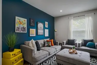 a living room with a couch and a blue wall at Housepitality - The Lilley Pad - Near Downtown in Columbus