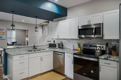 a kitchen with white cabinets and stainless steel appliances at Housepitality - The Lilley Pad - Near Downtown in Columbus