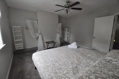 a bedroom with a bed and a ceiling fan at Housepitality - Franklinton Manor - Spacious in Columbus