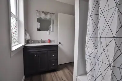 a bathroom with a sink and a mirror at Housepitality - Franklinton Manor - Spacious in Columbus