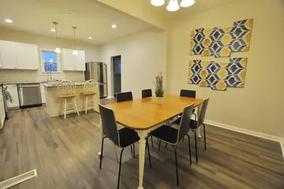 a kitchen and dining room with a wooden table and chairs at Housepitality - Franklinton Manor - Spacious in Columbus