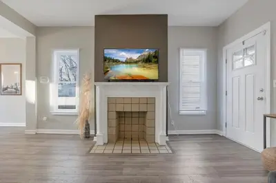 a living room with a fireplace and a painting on the wall at Housepitality - The Southwestern in Columbus