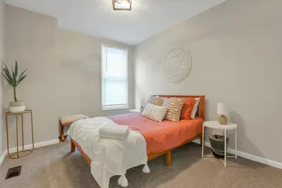 a bedroom with a bed with orange sheets and pillows at Housepitality - The Southwestern in Columbus