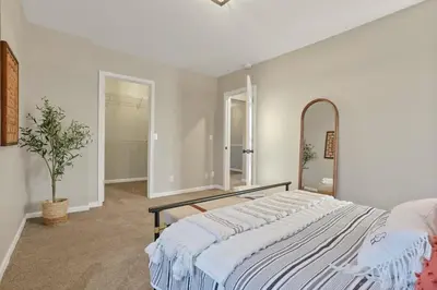 a bedroom with a large bed and a mirror at Housepitality - The Southwestern in Columbus