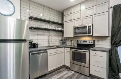 a kitchen with white cabinets and stainless steel appliances at Housepitality - The Mint Julep House in Columbus