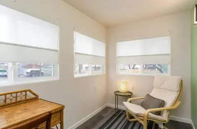 a room with a chair and a desk and windows at Housepitality - The Mint Julep House in Columbus