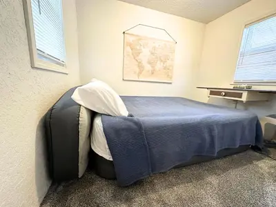 a bedroom with a bed with a blue blanket at King Bed, 2 Full Baths, Large Deck, Free Bikes, 2 miles to Downtown & Sports Fieldhouse in Fort Wayne