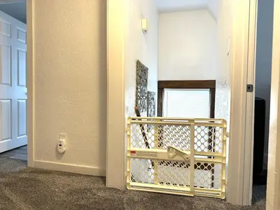 a hallway with a door with a gold gate at King Bed, 2 Full Baths, Large Deck, Free Bikes, 2 miles to Downtown & Sports Fieldhouse in Fort Wayne