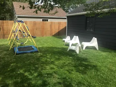 three white chairs and a swing in a yard at Bexley Family Friendly, Staycation, King Bed in Columbus