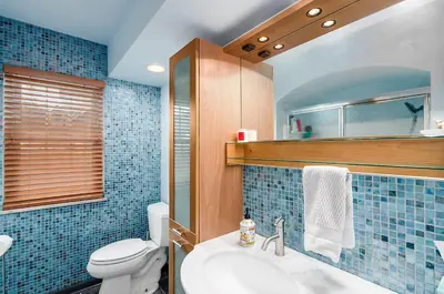 a bathroom with a sink and a toilet and blue tiles at Bexley Family Friendly, Staycation, King Bed in Columbus
