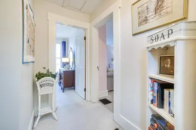 a hallway with a book shelf with books at The Porch House Located in Historic Village in Granville