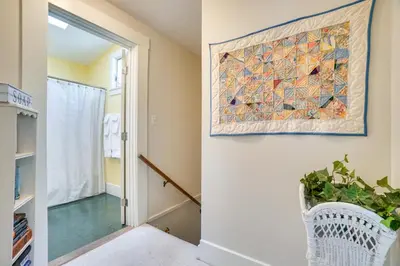 a hallway with a painting on the wall next to a door at The Porch House Located in Historic Village in Granville