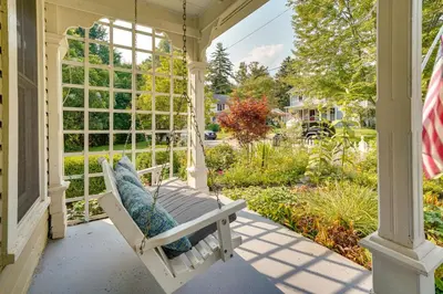 a porch swing with a view of a garden at The Porch House Located in Historic Village in Granville