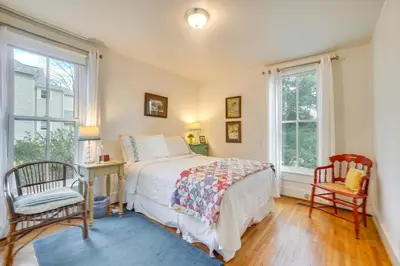 a bedroom with a bed and a desk and two chairs at The Porch House Located in Historic Village in Granville