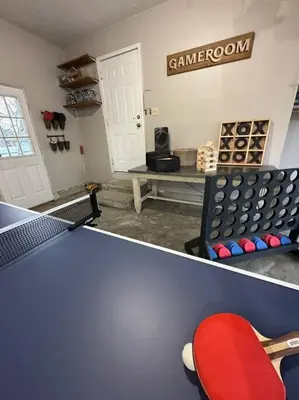 a room with a ping pong table and a bench at Cheerful 4 bedroom home w/ fireplace & game room in Mason