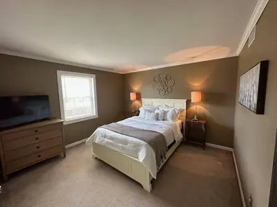 a bedroom with a large bed and a flat screen tv at Cheerful 4 bedroom home w/ fireplace & game room in Mason