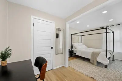 a bedroom with a large bed and a mirror at The Lakewood Belle: Family Friendly Home 10 minutes to Downtown! in Cleveland