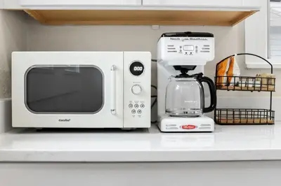 a microwave and a coffee maker on a counter at The Lakewood Belle: Family Friendly Home 10 minutes to Downtown! in Cleveland