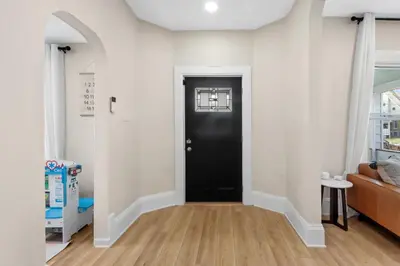 a hallway with a black door in a living room at The Lakewood Belle: Family Friendly Home 10 minutes to Downtown! in Cleveland