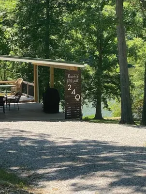 a sign in front of a pavilion with a table and benches at Lakehouse Hot Tub & Pool close to Ark Encounter in Corinth