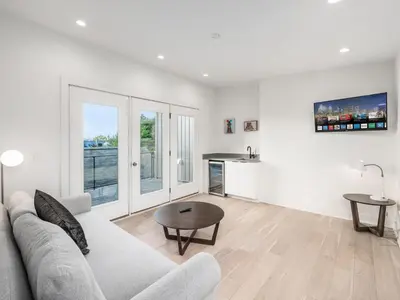 a white living room with a couch and a table at Historic German Village Industrial Masterpiece in Columbus