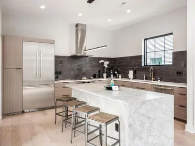 a kitchen with a large marble counter and stools at Historic German Village Industrial Masterpiece in Columbus